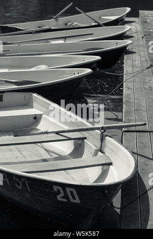 Schwarz-weiß Foto von ruderbooten auf dem Pier Stockfoto