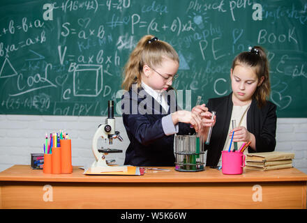 Genius Kinder arbeiten an eigenen chemischen Theorie. Grundkenntnisse der Chemie. Schüler nette Mädchen Röhrchen mit Flüssigkeiten verwenden. Chemisches experiment Konzept. Sicherheitsmaßnahmen für die sichere chemische Reaktion. Stockfoto