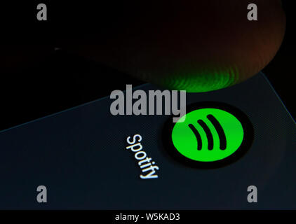 Spotify App auf dem Bildschirm des Smartphones mit sichtbaren Pixel und die Finger über Sie zu starten. Stockfoto