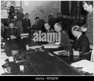 Englisch: Colonal General Alfred Jodl, Chef des Stabes unter dem doenitz Regime, Zeichen der bedingungslosen Kapitulation. Auf Jodl was Links ist General Admiral von friedeburg der Deutschen Marine, und auf der rechten Seite ist die große Wilhelm Oxenius der Allgemeinen Deutschen Personal. Hinter von Friedeburg ist Generalmajor K.W.D. Starke, G-2, SHAEF English: v. l. n. r: Major Wilhelm Oxenius (Adjutant von Generaloberst Jodl), Generaloberst Alfred Jodl, Chef des Dt. Wehrmachtführungsstabes (die Kapitulationsurkunde u.a. des OKW unterzeichnend), Generaladmiral Hans-Georg von Friedeburg, Oberbefehlshaber der Dt. Kriegsmarin Stockfoto