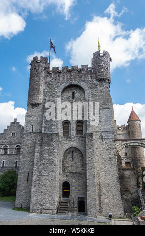 Gent, Flandern, Belgien - 21. Juni 2019: grauen Stein Turm und die angrenzenden Gebäude der Burg Gravensteen, historischen mittelalterlichen Burg der Stadt gegen den blauen Himmel wi Stockfoto