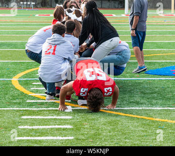 High school Kinder spielen Tauziehen auf einen grünen Rasenfeld. Stockfoto