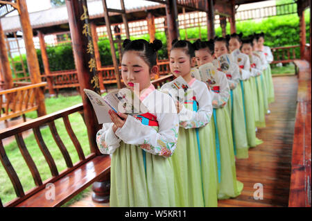 Chinesische Studenten in hanfu oder traditionellen chinesischen Kostüm lesen Klassiker gekleidet in der World Book Day in Zigui County, Yichang City, Central Kinn zu begrüßen Stockfoto