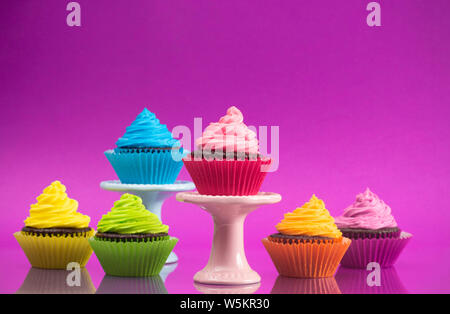 Regenbogenfarbige Frosted Chocolate Cupcakes für eine Partei gesetzt Stockfoto