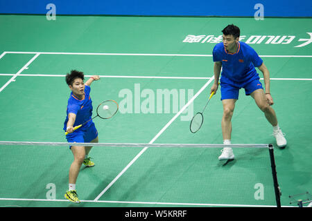 Wang Yilyu und Huang Dongping von China wieder einen Schuß zu er Jit und Du Yue aus China in ihrem letzten Spiel der gemischten Doppel während der 2019 Badminton Stockfoto