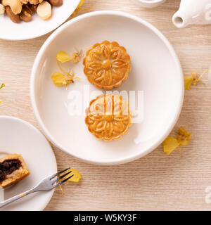 Köstliche mond Kuchen für das Mondfest mit schönen Muster, mit gelben Blumen und Kaffee ausgestattet. Konzept der festlichen Nachmittag Gebäck design Stockfoto