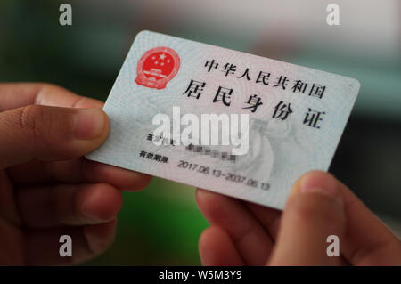 ---- Ein Bürger zeigt seine ID-Karte in Ji'Nan, der ostchinesischen Provinz Shandong, den 9. April 2018. Die Shanghaier Regierung hat Gerüchte, dass Th verweigert Stockfoto
