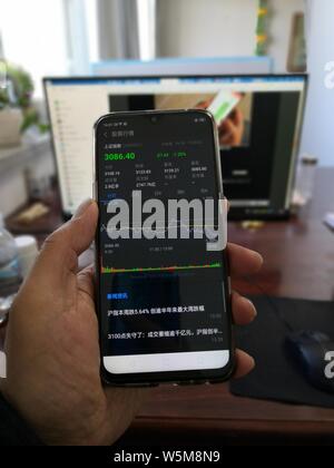 Ein Chinesischer Investor zeigt sein Smartphone anzeigen der Shanghai Composite Index in Qiqihar City, im Nordosten der chinesischen Provinz Heilongjiang, 26. April 201 Stockfoto