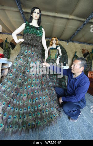 Chinesische hofbesitzers Xia Linrong zeigt ein Brautkleid aus Pfauenfedern in De' eine Grafschaft, Conghua City, der ostchinesischen Provinz Jiangxi, 16 Stockfoto