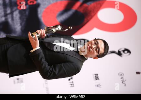 Der chinesische Regisseur Wen Muye wirft mit Trophäe für den "Besten Film aus dem Festland China und Taiwan: Sterben an der 38th Hong Kong Film Awards (HKFA zu Überleben" Stockfoto