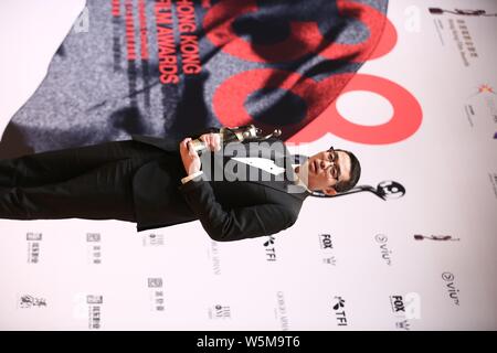 Der chinesische Regisseur Wen Muye wirft mit Trophäe für den "Besten Film aus dem Festland China und Taiwan: Sterben an der 38th Hong Kong Film Awards (HKFA zu Überleben" Stockfoto