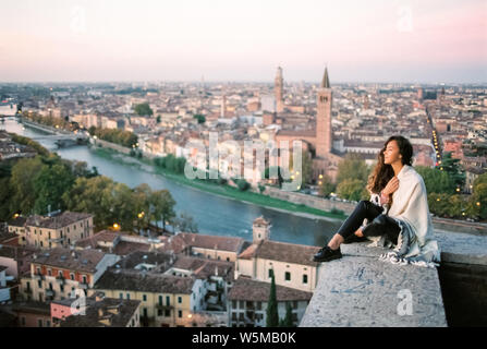 Junge Frau genießen Sie einen wunderschönen Blick auf die Stadt Verona in Italien in den Morgen. Berühmte italienische Stadt der Liebe. Film Foto. Stockfoto