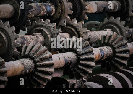 Nahaufnahme von schmutzigen industriellen Metallzahnrädern und Maschinen-Zahnrädern in einer Fabrikumgebung Stockfoto