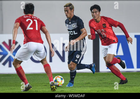 Keisuke Honda, Mitte, der von Australien Melbourne Victory Herausforderungen Gao Lin, Links, und Park Ji-soo in China Guangzhou Evergrande während ihrer Gruppe F Stockfoto