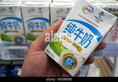 ---- Ein Kunde Geschäfte für einen Karton Yili reine Milch in einem Supermarkt in Changzhou Stadt, im Osten der chinesischen Provinz Jiangsu, 30. März 2019. Chinesisch da Stockfoto