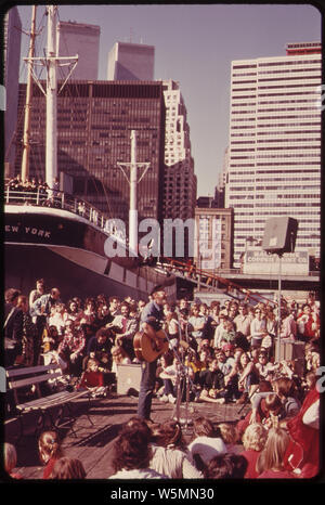 FOLK Sänger und Publikum in South Street Seaport auf dem East River in der Nähe der Brooklyn Bridge. Begeisterte Zuschauer VERSAMMELN SICH MEHRMALS IN DER WOCHE ZU GENIESSEN SIE DIE MUSIK, DAS MEER UND DEN HAFEN SEHENSWÜRDIGKEITEN Stockfoto