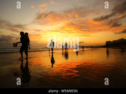 Die Menschen genießen Freizeit inmitten Abendrot am Meer in Sanya City, South China Hainan Provinz, 22. April 2019. Stockfoto