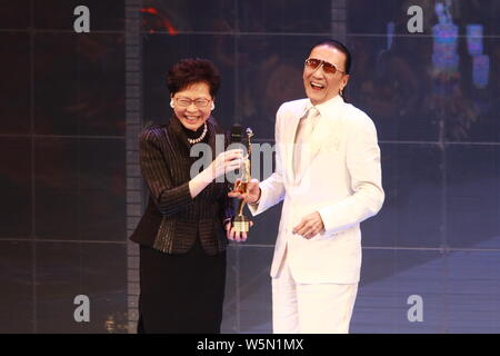 Hong Kong Chief Executive Carrie Lam Cheng Yuet-ngor präsentiert den "Lifetime Achievement Award" Trophäe zu Hong Kong Schauspieler und Produzenten Patrick Tse-duri Stockfoto