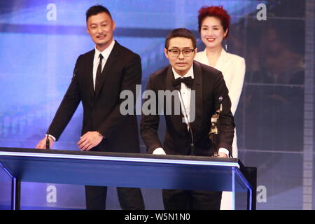 Der chinesische Regisseur Wen Muye wirft mit Trophäe für den "Besten Film aus dem Festland China und Taiwan: Sterben an der 38th Hong Kong Film Awards (HKFA zu Überleben" Stockfoto