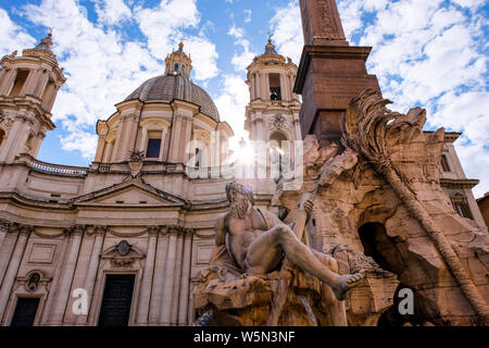 Sonnenlicht durch die Piazza Navona, die Fontana dei Quattro Fiumi und Sant'Agnese in Agone Kirche in Rom, Italien Stockfoto