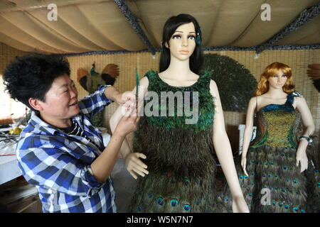 Chinesische hofbesitzers Xia Linrong zeigt ein Brautkleid aus Pfauenfedern in De' eine Grafschaft, Conghua City, der ostchinesischen Provinz Jiangxi, 16 Stockfoto