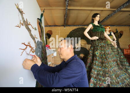 Chinesische hofbesitzers Xia Linrong zeigt ein Brautkleid aus Pfauenfedern in De' eine Grafschaft, Conghua City, der ostchinesischen Provinz Jiangxi, 16 Stockfoto