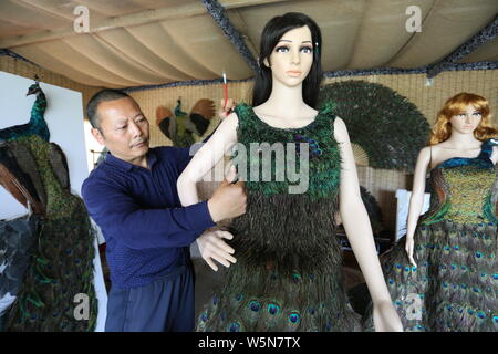 Chinesische hofbesitzers Xia Linrong zeigt ein Brautkleid aus Pfauenfedern in De' eine Grafschaft, Conghua City, der ostchinesischen Provinz Jiangxi, 16 Stockfoto