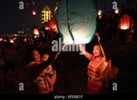 Touristen und Menschen von Dai ethnische Gruppe release Himmelslaternen, auch als Laternen Kongming bekannt, bei der Bank von lancang River Der 1381st Ne zu feiern. Stockfoto