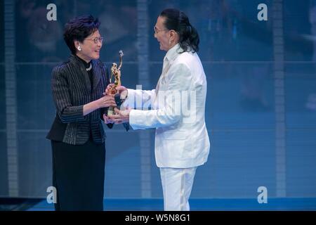 Hong Kong Chief Executive Carrie Lam Cheng Yuet-ngor präsentiert den "Lifetime Achievement Award" Trophäe zu Hong Kong Schauspieler und Produzenten Patrick Tse-duri Stockfoto