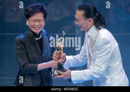 Hong Kong Chief Executive Carrie Lam Cheng Yuet-ngor präsentiert den "Lifetime Achievement Award" Trophäe zu Hong Kong Schauspieler und Produzenten Patrick Tse-duri Stockfoto