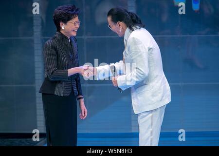 Hong Kong Chief Executive Carrie Lam Cheng Yuet-ngor präsentiert den "Lifetime Achievement Award" Trophäe zu Hong Kong Schauspieler und Produzenten Patrick Tse-duri Stockfoto