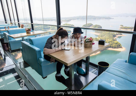 Touristen genießen die Landschaft auf der 99 Meter hohen gläsernen Turm an der Lushan Xihai scenic Spot in Conghua City, der ostchinesischen Provinz Jiangxi, 7 Ap Stockfoto