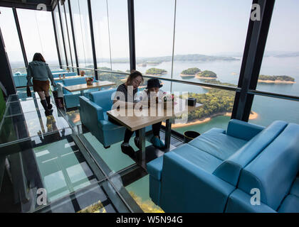 Touristen genießen die Landschaft auf der 99 Meter hohen gläsernen Turm an der Lushan Xihai scenic Spot in Conghua City, der ostchinesischen Provinz Jiangxi, 7 Ap Stockfoto