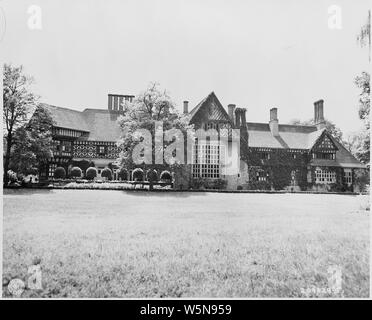 Vor dem Schloss Cecilienhof, Schauplatz der Potsdamer Konferenz in Potsdam, Deutschland. Links im Bild ist der Abschnitt verwendet wie der britische Viertel. Das große Fenster in der Mitte sind die Der amerikanischen Delegation und Präsident Truman. In der Mitte, genau das Richtige, der Konferenzraum, in einem eher dunklen Raum, sind die Fenster des Büros der sowjetische Staatschef Josef Stalin. Stockfoto