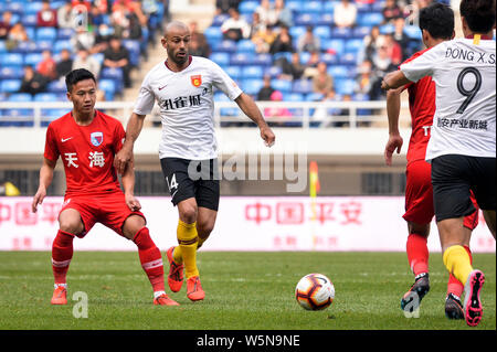 Argentinische Fußballspieler Javier Mascherano, Links, Hebei China Fortune passt den Ball gegen Spieler von Tianjin Tianhai in der 4. Runde Stockfoto
