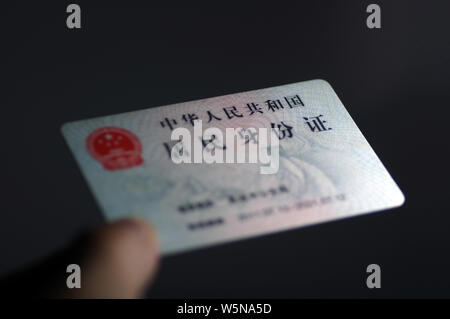 ---- Ein Bürger zeigt seine ID-Karte in Ji'Nan, der ostchinesischen Provinz Shandong, 6. Oktober 2016. Die Shanghaier Regierung hat Gerüchte, der verweigert Stockfoto