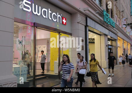 ---- Fußgänger vorbei an einem Geschäft der Schweizer Uhrenhersteller Swatch in Shanghai, China, 30. August 2017. Schweizer Uhrenhersteller Swatch hat eine Collaborativ Stockfoto
