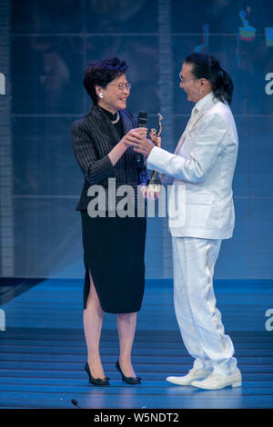 Hong Kong Chief Executive Carrie Lam Cheng Yuet-ngor präsentiert den "Lifetime Achievement Award" Trophäe zu Hong Kong Schauspieler und Produzenten Patrick Tse-duri Stockfoto