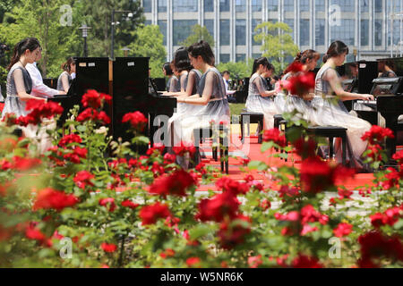 Die Teilnehmer spielen Klavier bilden die Form der 70 70. Jahrestag der Gründung der Volksrepublik China während einen Wettbewerb, der sich an die Mitteilung Unive zu feiern. Stockfoto