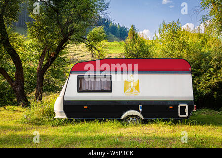 Ein PKW-Anhänger, Wohnmobil, in der nationalen Flagge Ägypten lackiert steht in einer bergigen geparkt. Das Konzept des Straßenverkehrs, der Handel, Export und im Stockfoto