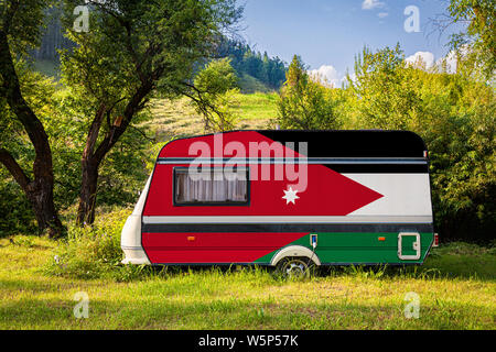 Ein PKW-Anhänger, Wohnmobil, in der nationalen Flagge Jordanien lackiert steht in einer bergigen geparkt. Das Konzept des Straßenverkehrs, der Handel, Export und ich Stockfoto