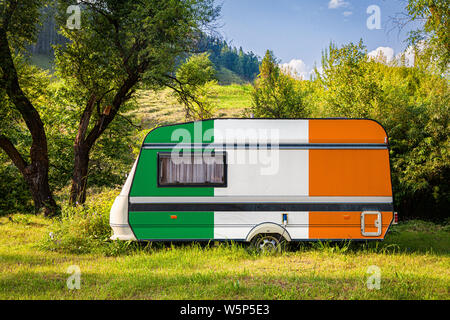 Ein PKW-Anhänger, Wohnmobil, in der nationalen Flagge von Irland malte steht in einer bergigen geparkt. Das Konzept des Straßenverkehrs, der Handel, Export und Stockfoto