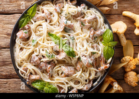 Köstliche Spaghetti mit gebratenen Pfifferlingen in einer cremigen Käse sauce Close-up auf einem Teller auf den Tisch. Horizontal oben Ansicht von oben Stockfoto