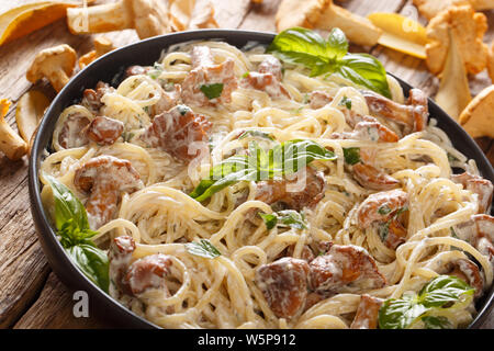 Köstliche Spaghetti mit gebratenen Pfifferlingen in einer cremigen Käse sauce Close-up auf einem Teller auf den Tisch. Horizontale Stockfoto