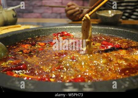 ------ Kunden genießen einen würzigen heißen Topf auf einen hotpot Restaurant in Chongqing, China, 15. September 2017. Stockfoto