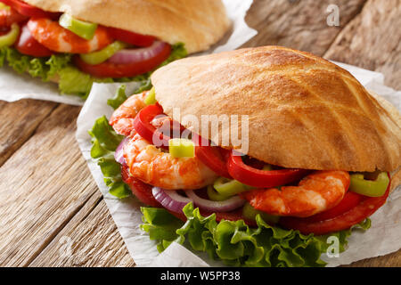 Frisches Fladenbrot mit Riesengarnelen, Gemüse close-up auf Pergament auf den Tisch. Horizontale Stockfoto