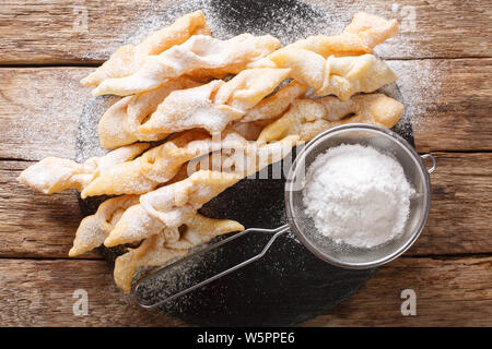 Frisch Angel Wings Plätzchen mit Puderzucker close-up auf den Tisch. horizontal oben Ansicht von oben Stockfoto