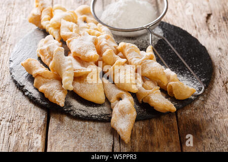 Polnisch Dessert faworki mit Puderzucker close-up auf dem Tisch. Horizontale Stockfoto