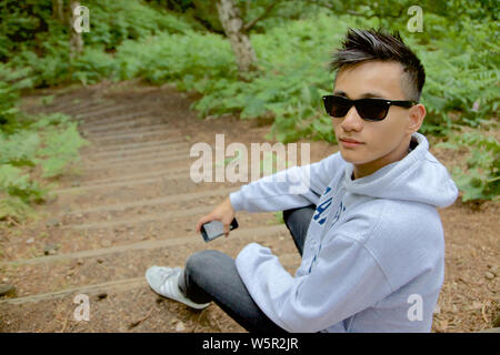 Ein junger Kerl an der Kamera in einem Forrest suchen, England Stockfoto