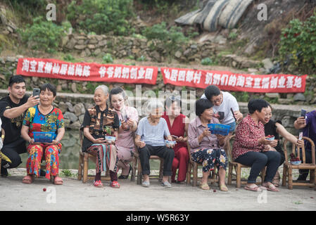 Lokale Knaben helfen Senioren live streaming webcast Ihre lokale Spezialität, Yangmei oder Chinesischen bayberry zu verkaufen, auf Alibaba's e-commerce platfor Stockfoto